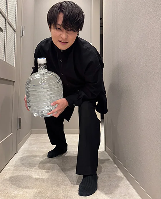 重いボトルを運ぶ男性